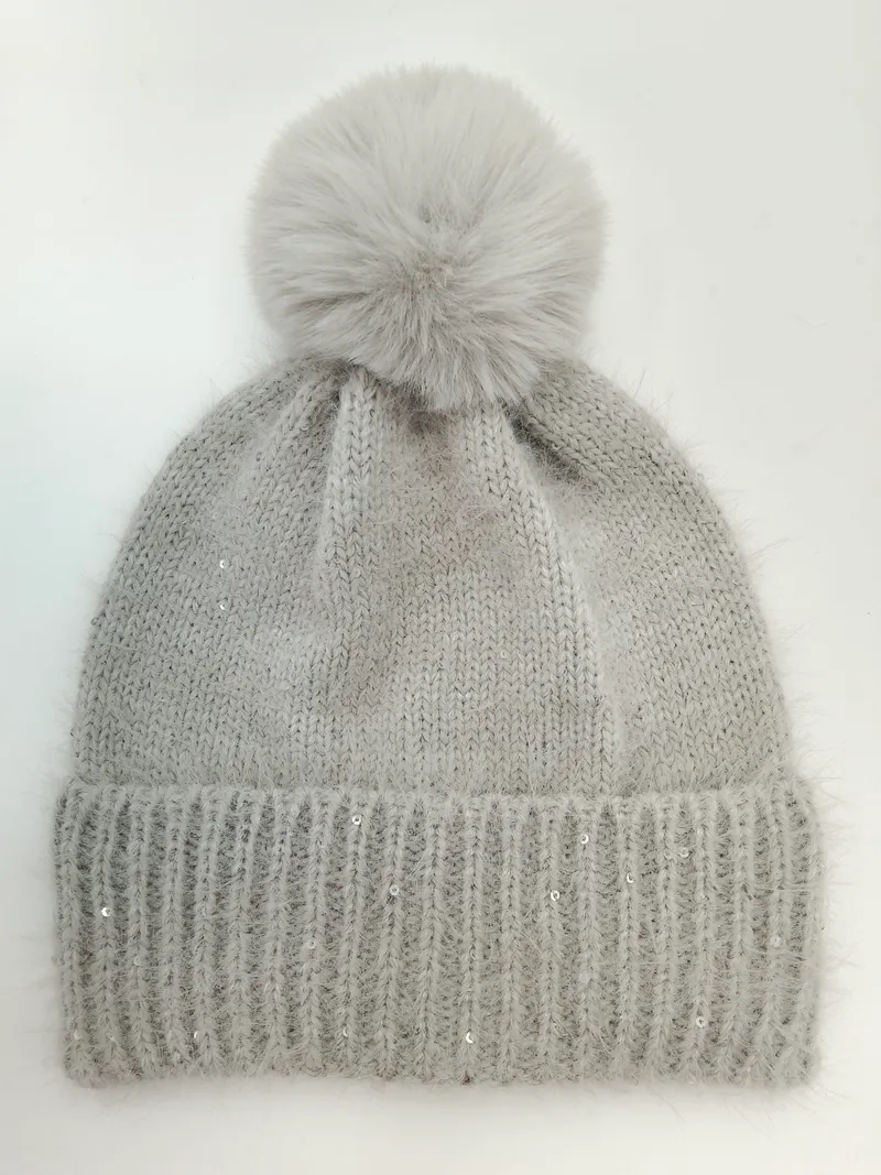 Hellgraue flauschige Winterstrickmütze mit großem Kunstfell-Bommel und silbernen Paillettenakzenten