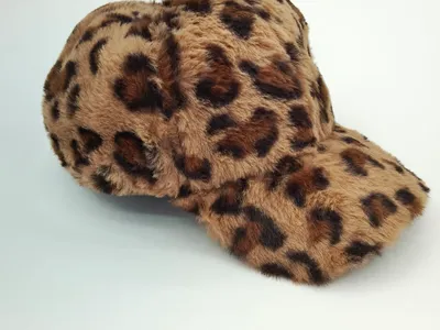 Fluffige Baseball-Cap aus Kunstfell mit braun-schwarzem Leoparden-Cheetah-Muster auf weißem Hintergrund
