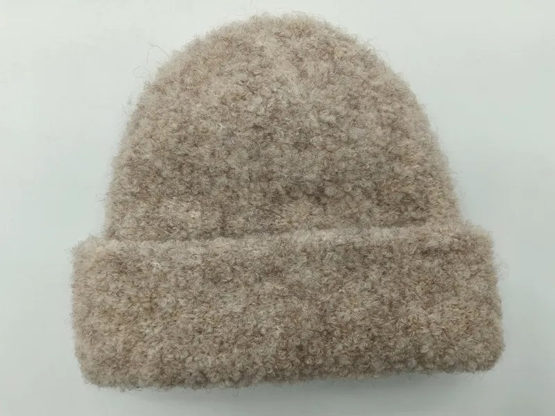 Beige-oatmeal Bouclé-Strickmütze mit Umschlag und flauschiger Garnstruktur, Draufsicht auf weißem Hintergrund
