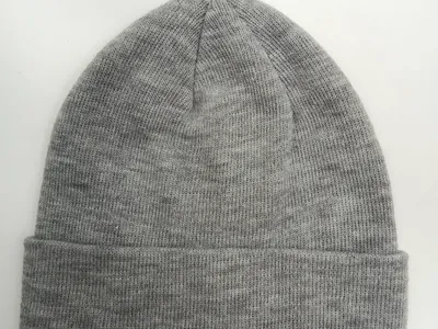 Melierte Grau-Strickmütze in klassischem Unisex-Schnitt mit gefalteter Krempe auf weißem Hintergrund