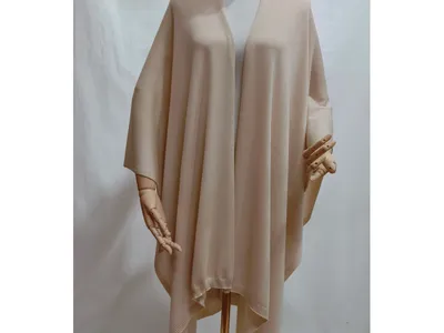 Creme-beigefarbener, großzügig geschnittener Strickponcho mit offenem Vorderteil und geripptem Saum auf einer Schneiderpuppe