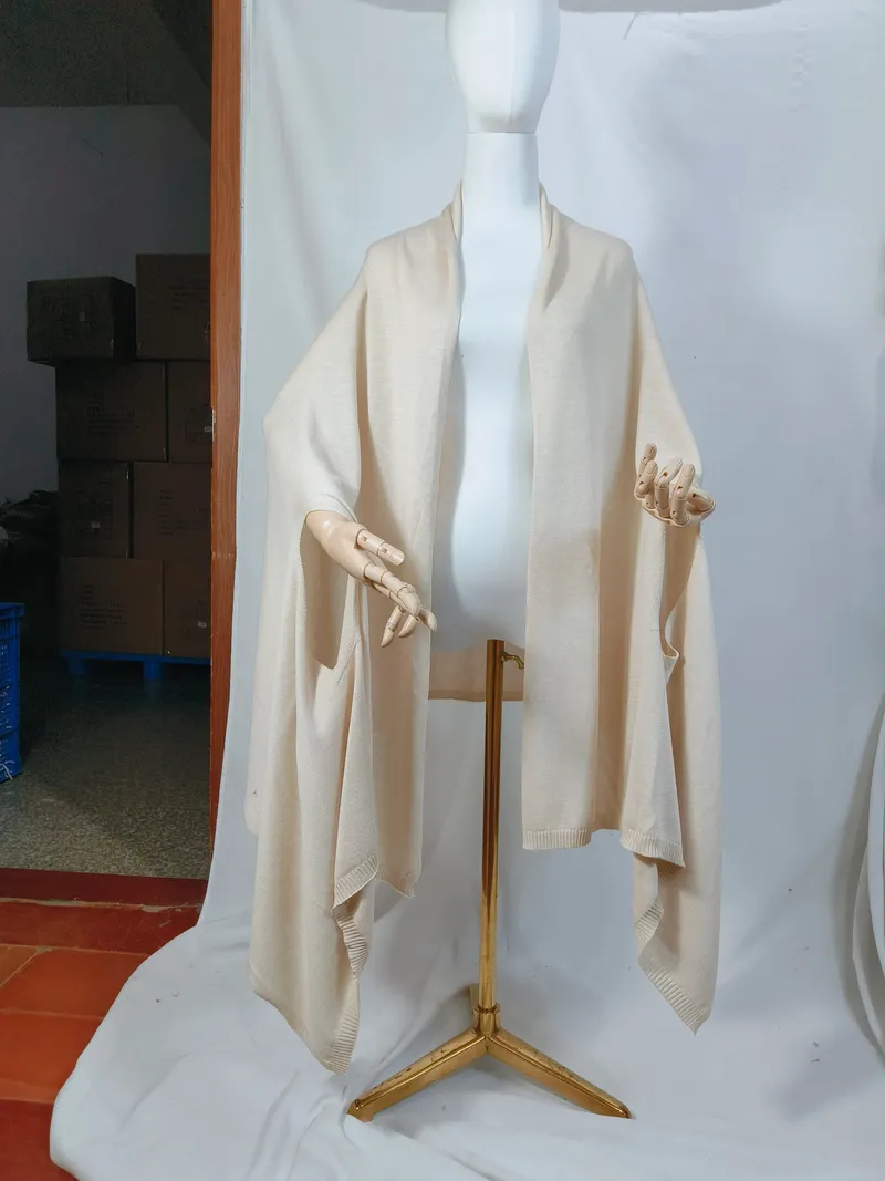 Cremefarbenes, elfenbeinfarbenes Feinstrick-Wickelshawl auf einer Schneiderpuppe, offene Vorderseite mit geripptem Abschluss und weitem Drapee