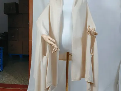 Cremefarbenes, elfenbeinfarbenes Feinstrick-Wickelshawl auf einer Schneiderpuppe, offene Vorderseite mit geripptem Abschluss und weitem Drapee