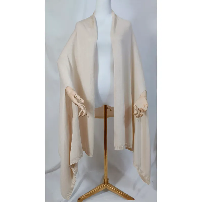 Helles Creme-Strickshawl locker drapiert auf Schneiderpuppe mit Holzhänden und goldenem Stativständer, Poncho-Stil mit offenem Vorderteil