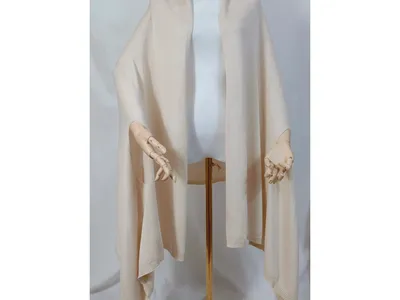 Helles Creme-Strickshawl locker drapiert auf Schneiderpuppe mit Holzhänden und goldenem Stativständer, Poncho-Stil mit offenem Vorderteil