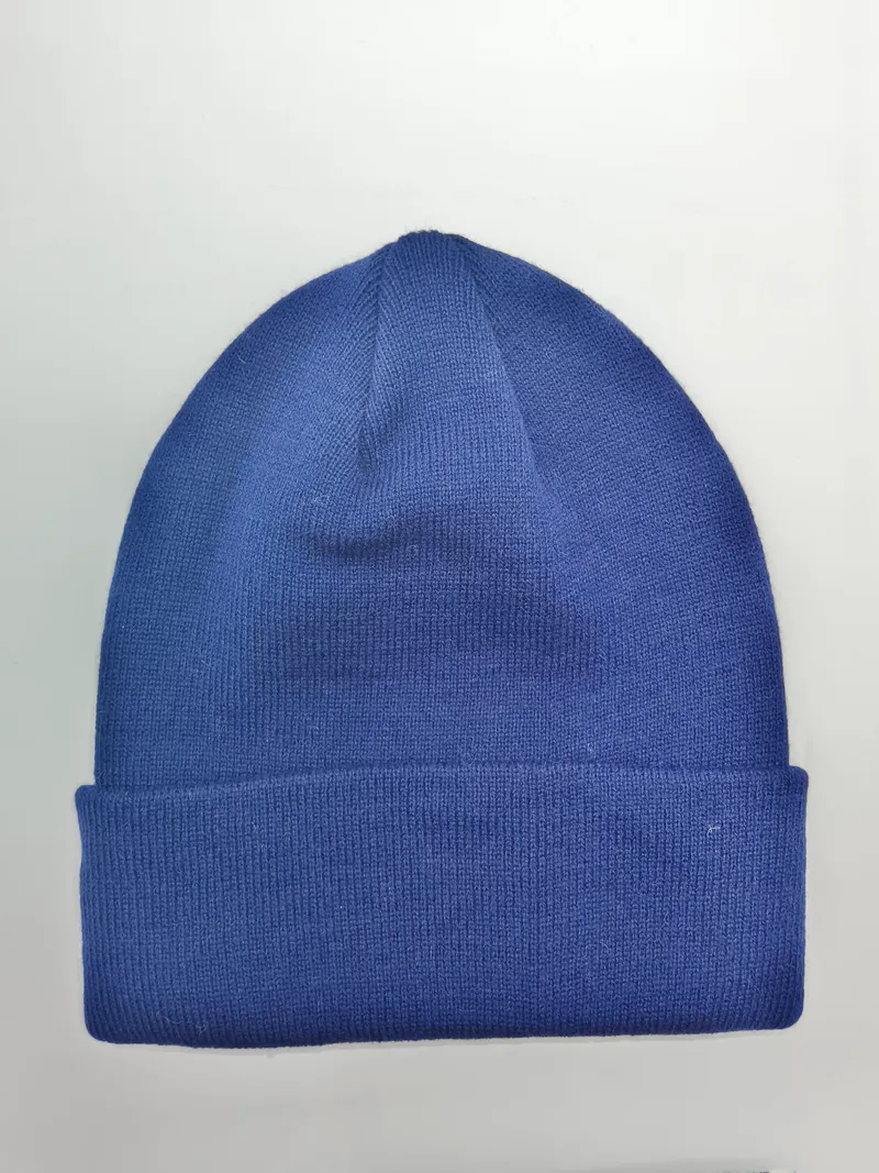 Unifarbene royalblaue Strickmütze mit gefaltetem Rippenbund, flach auf weißem Untergrund fotografiert, unisex Wintercap