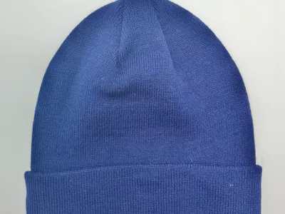 Unifarbene royalblaue Strickmütze mit gefaltetem Rippenbund, flach auf weißem Untergrund fotografiert, unisex Wintercap