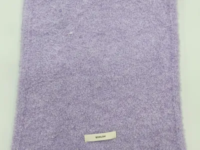 Gefaltete weiche Kuscheldecke in Fliederviolett mit Boucle-Oberfläche und kleinem Etikett auf weißem Hintergrund