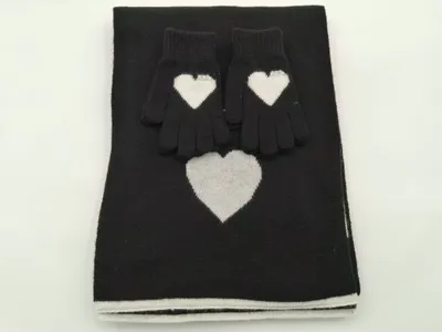 Schwarzes Strick-Set aus gefaltetem Schal und Handschuhen mit weißem Intarsia-Herzmuster auf weißem Hintergrund