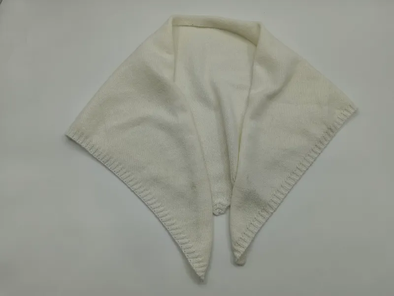 Elfenbein cremefarbener gestrickter Wickelschal mit spitzen Enden, dekorativem Muschelrand und offenem Kragen-Detail auf weißem Hintergrund