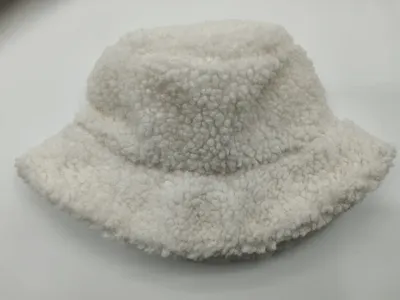 Cremeweiße Sherpa-Fischermütze mit fluffiger Boucle-Textur auf weißem Hintergrund, weiches Winter-Accessoire