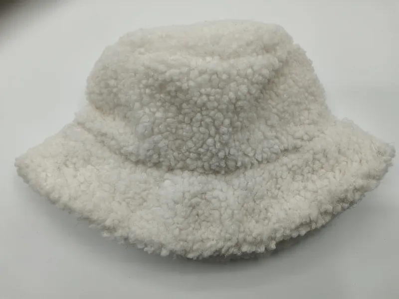 Cremeweiße Sherpa-Fischermütze mit fluffiger Boucle-Textur auf weißem Hintergrund, weiches Winter-Accessoire