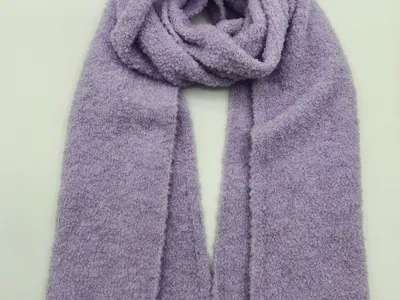 Weicher fliedervioletter Boucle-Strickschal locker aufgewickelt auf weißem Hintergrund mit fluffiger Gewebetextur und gerippten Enden