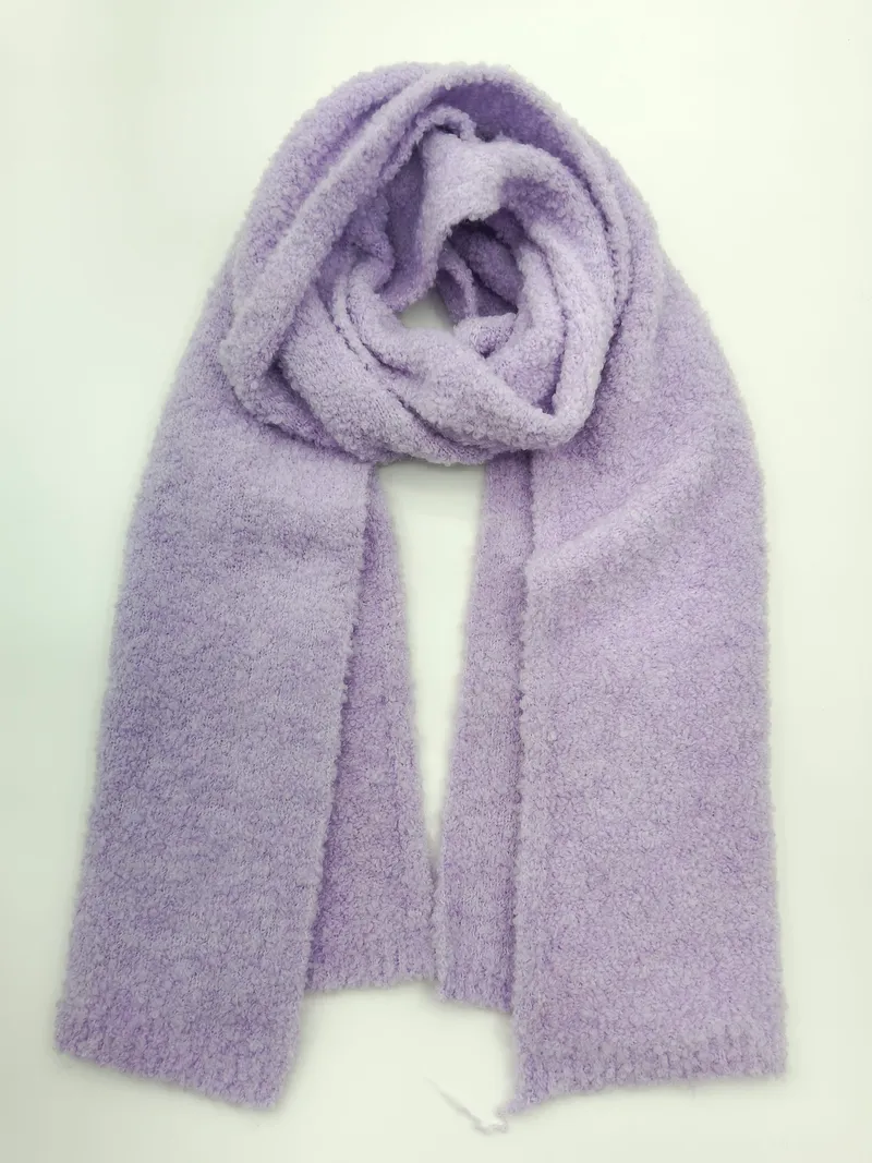 Weicher fliedervioletter Boucle-Strick Oversized-Schal zusammengelegt und flach auf weißem Hintergrund liegend
