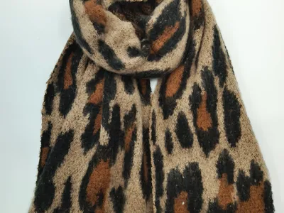 Aufgerollter Flauschstrickschal mit weichem Leopardenmuster in warmen Beige-, Braun- und Schwarztönen