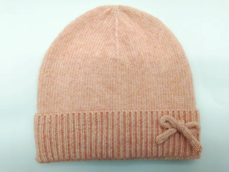 Weiche pfirsichfarbene Melange-Strickmütze mit gefaltetem Rippenbündchen und dekorativem gestricktem Schleifenapplikation