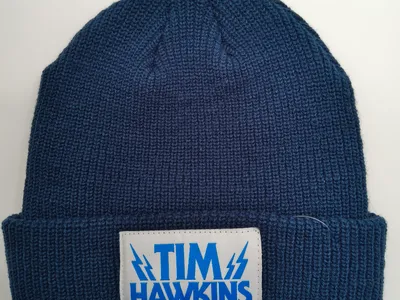 Dunkelblaue Umschlagmütze aus Rippenstrick mit gewebtem Blitz-Logo-Patch in Weiß und Blau auf dem Bündchen