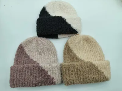 Drei zweifarbige Strickmützen in den Kombinationen Schwarz-Creme, Mauve-Blush und Sand-Khaki mit Rippbündchen auf weißem Hintergrund