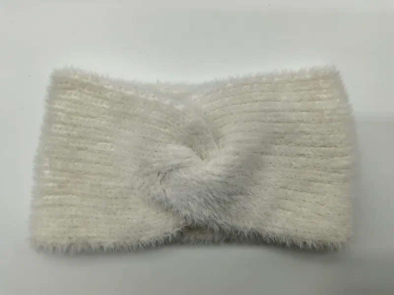 Weiches cremefarbenes Haarband aus flauschigem Rippstrick mit dekorativem Twist-Knoten in der Mitte, auf hellem Untergrund