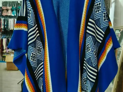 Offener Strick-Kimono-Cardigan in Royalblau mit geometrischem Diamantmuster in Weiß, Schwarz und Orange auf Kleiderbügel