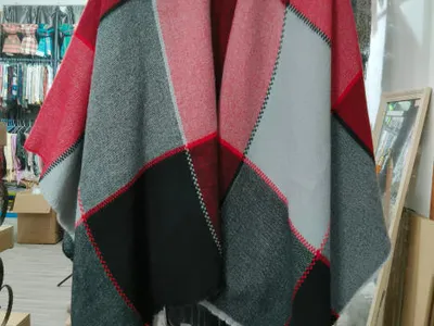 Großer Webe-Poncho mit geometrischem Colorblock-Muster in Rot, Grau und Schwarz auf Kleiderbügel