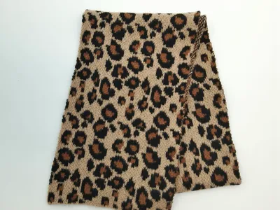 Zusammengefalteter Strickschlauchschal mit Leopardenmuster in Creme und Karamell auf weißem Hintergrund