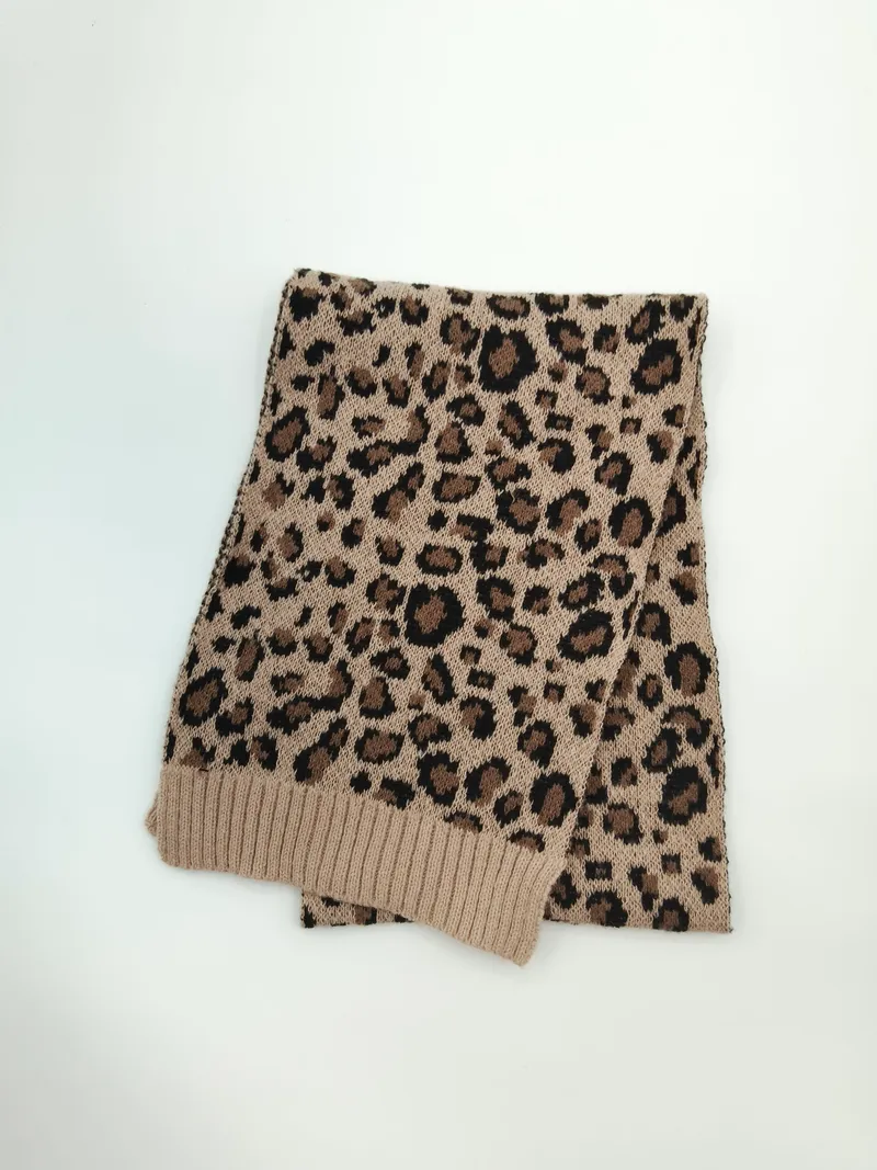 Gefalteter Strickschal mit Leopardenprint in Creme und Schwarz mit gerippten Abschlüssen auf weißem Hintergrund