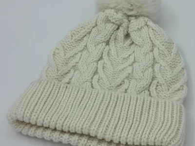 Wintermütze in Cremeweiss mit großem flauschigem Bommel, grobem Zopfstrickmuster und doppelt umgeschlagenem Rippenbündchen