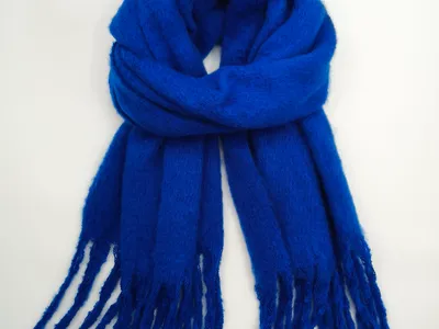 Royalblauer softer Mohair-Style-Schal locker drapiert mit langen gedrehten Fransenenenden auf weißem Hintergrund