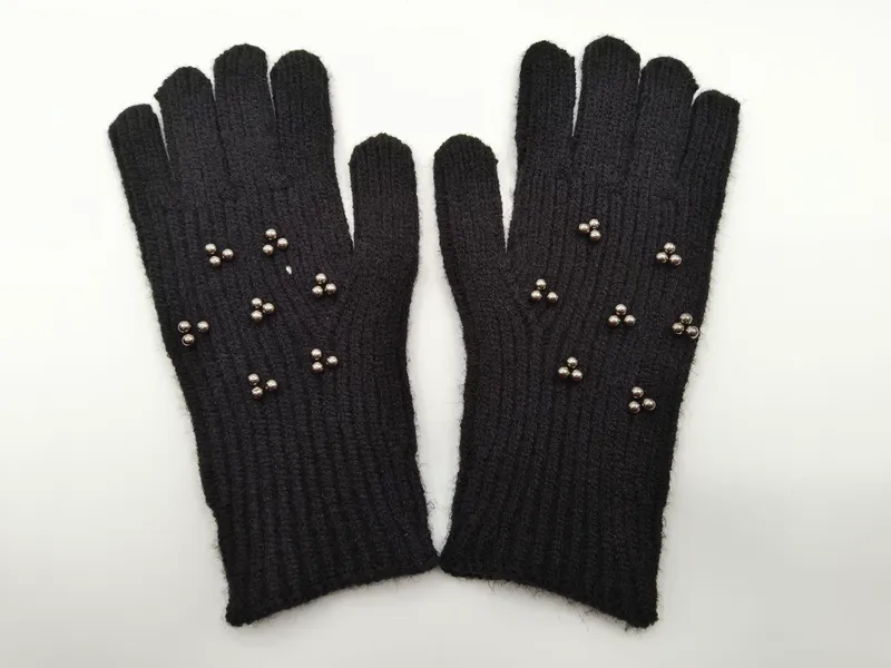 Paar schwarze gestrickte Winterhandschuhe mit silbernen Metallniet-Verzierungen auf dem Handrücken
