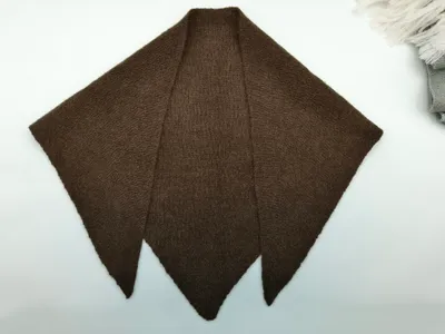 Dunkelbraunes handgestricktes Dreieck-Schultertuch mit drei Zacken, flach auf weißem Untergrund ausgelegt