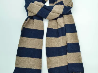 Breiter Strickschal mit marineblauen und beigefarbenen Blockstreifen sowie dekorativen Fransenquasten an den Enden
