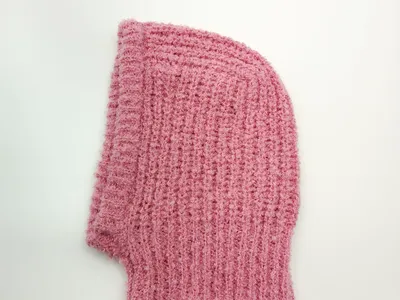 Pinkfarbene Skimaske aus kuscheligen Grobstrick mit Waffelstruktur – Flachansicht zeigt offene Strickoptik und Gesichtsausschnitt