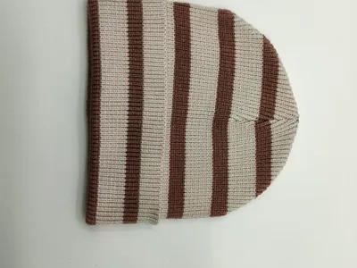 Gefaltete Rippenstrickmütze mit horizontalen Streifen in Braun und Naturweiß auf weißem Untergrund – Detailansicht der Strickstruktur