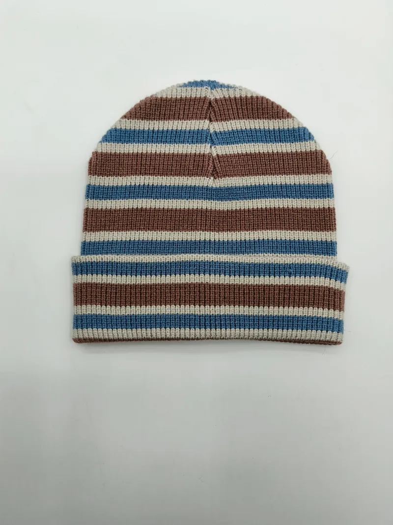 Rippenstrickmütze mit horizontalen Streifen in Blaugrau, Braun und Beige mit umgeklapptem Bündchen – flach auf weißem Untergrund