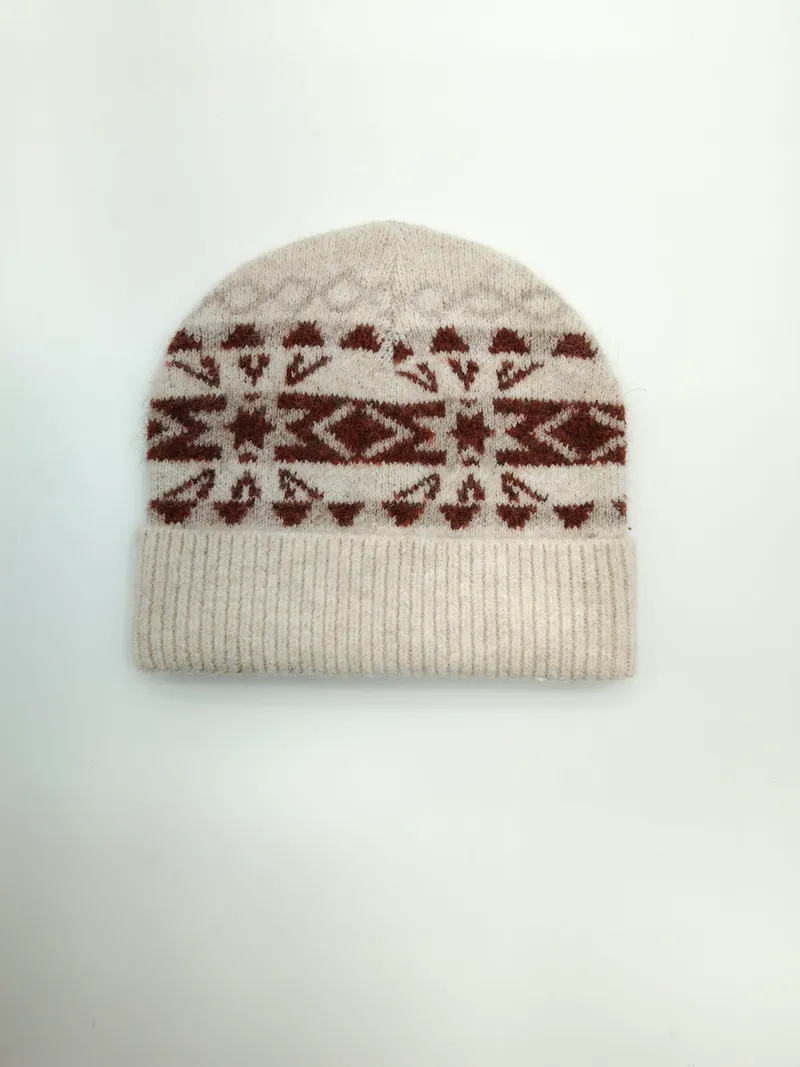 Wintermütze in Creme mit geometrischem Schneeflocken-Jacquardmuster in Terrakotta und umgeschlagenem Bündchen, Draufsicht auf hellem Untergrund