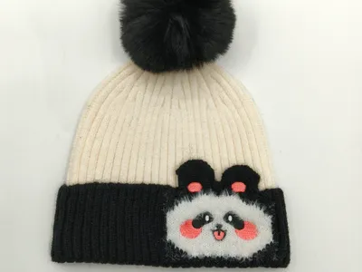 Weiß-schwarz gestreifte Rippenstrick-Beanie mit aufgenähtem Panda-Gesicht als Applikation und dunklem Kunstfell-Pompon, Wintermütze im Colorblock-Design