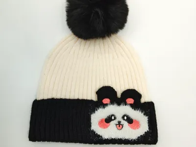 Zweiteilig gestalteter Rippenstrick-Beanie in Schwarz und Creme mit Panda-Motiv-Patch und voluminösem schwarzem Kunstfell-Bommel auf der Kuppe