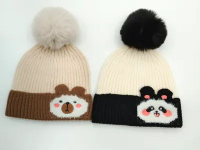 Zwei Rippenstrick-Beanies mit Bommeln: Bärenmotiv auf braunem Kontrastbündchen und Panda-Design auf schwarzem Kontrastbündchen, Draufsicht