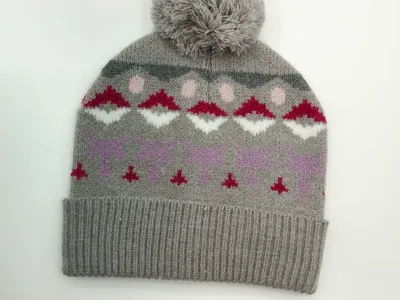 Graue Strick-Bommelmütze mit bunt gemustertem Fair-Isle-Design in Rot, Weiß, Rosa und Lavendel, Produktfoto auf weißem Hintergrund