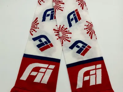 Gestrickter Fußball-Fanschal in Rot, Weiß und Blau mit Allover-Logo-Motiven und Feuerwerk-Ornamenten sowie roten Fransen an beiden Enden