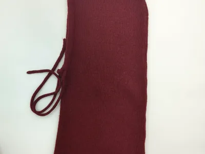 Dunkelroter gestrickter Nackenwärmer mit Kordelverschluss, Draufsicht auf weißem Hintergrund