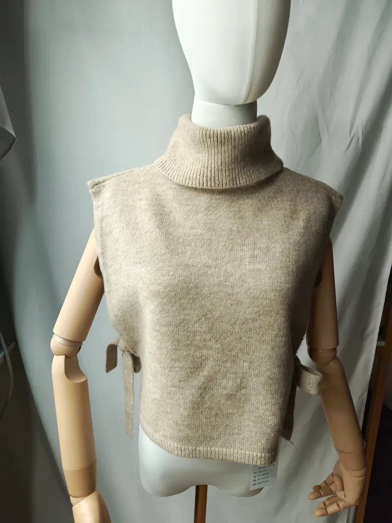 Cremefarbene ärmellose Rollkragen-Strickweste mit seitlichen Bindebändern auf einer Schneiderpuppe