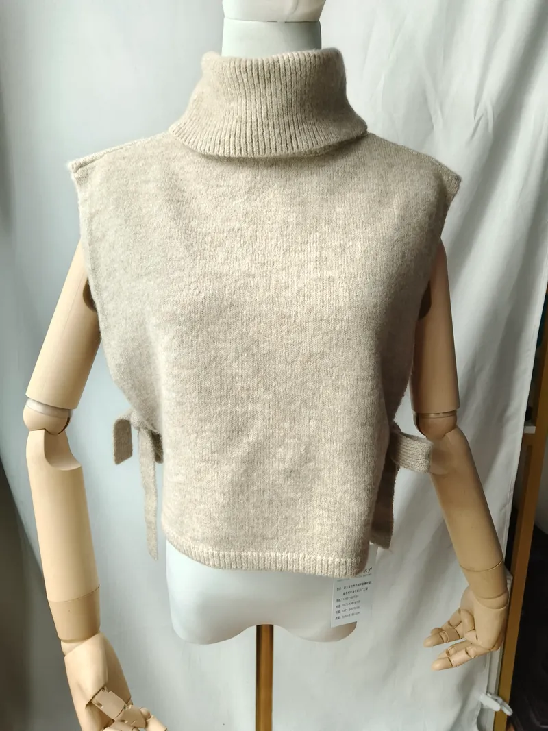 Beige ärmellose Rollkragen-Strickweste mit seitlichem Bindedetail auf einer Modelpuppe, weicher Wollmix