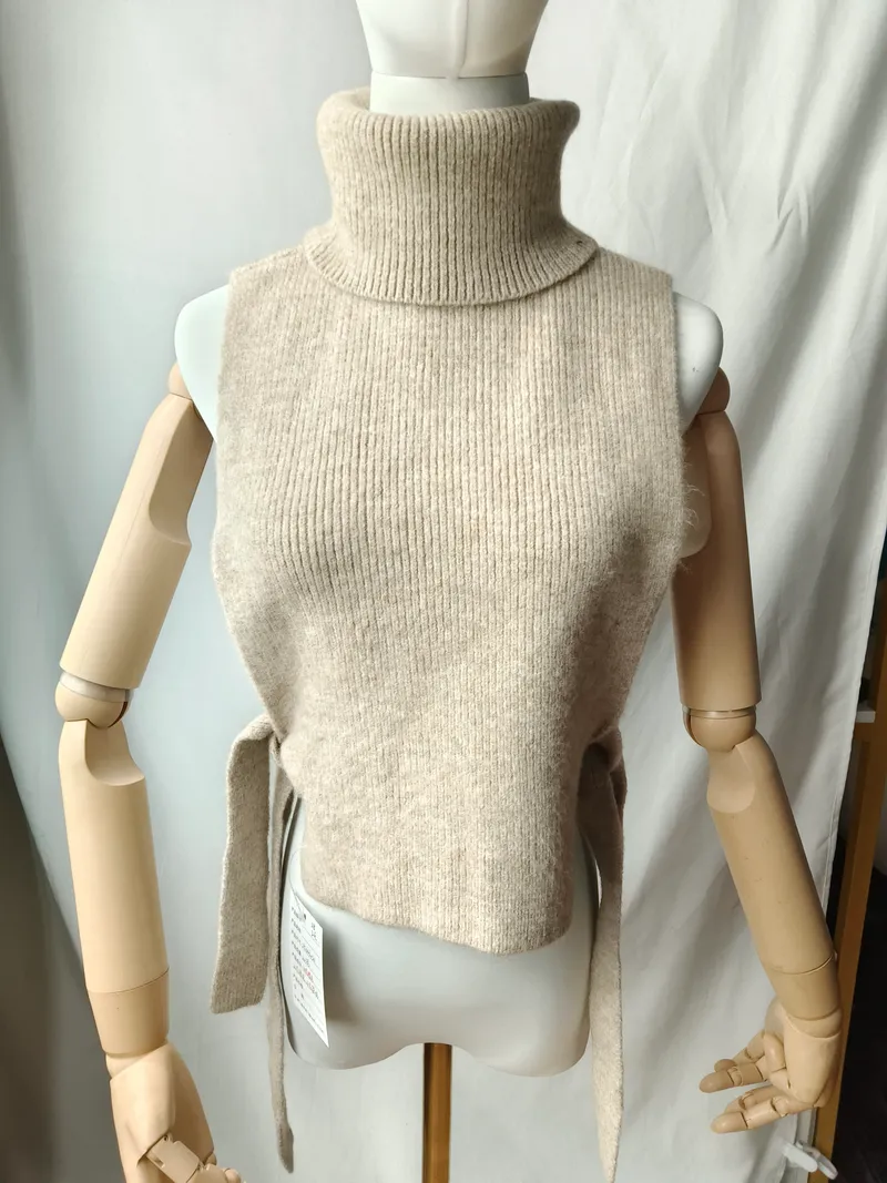 Haferbeige gerippte ärmellose Rollkragen-Strickweste mit Bindegürtel an der Taille auf einer Schaufensterpuppe, neu mit Etikett