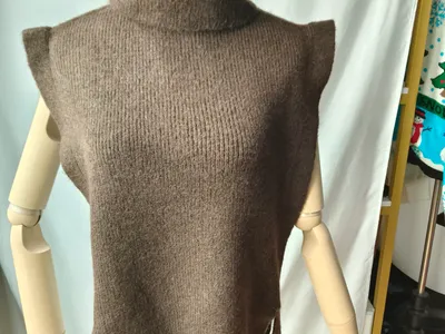Taupefarbene ärmellose Rollkragen-Strickweste mit Seitenband-Details auf einer Schneiderpuppe