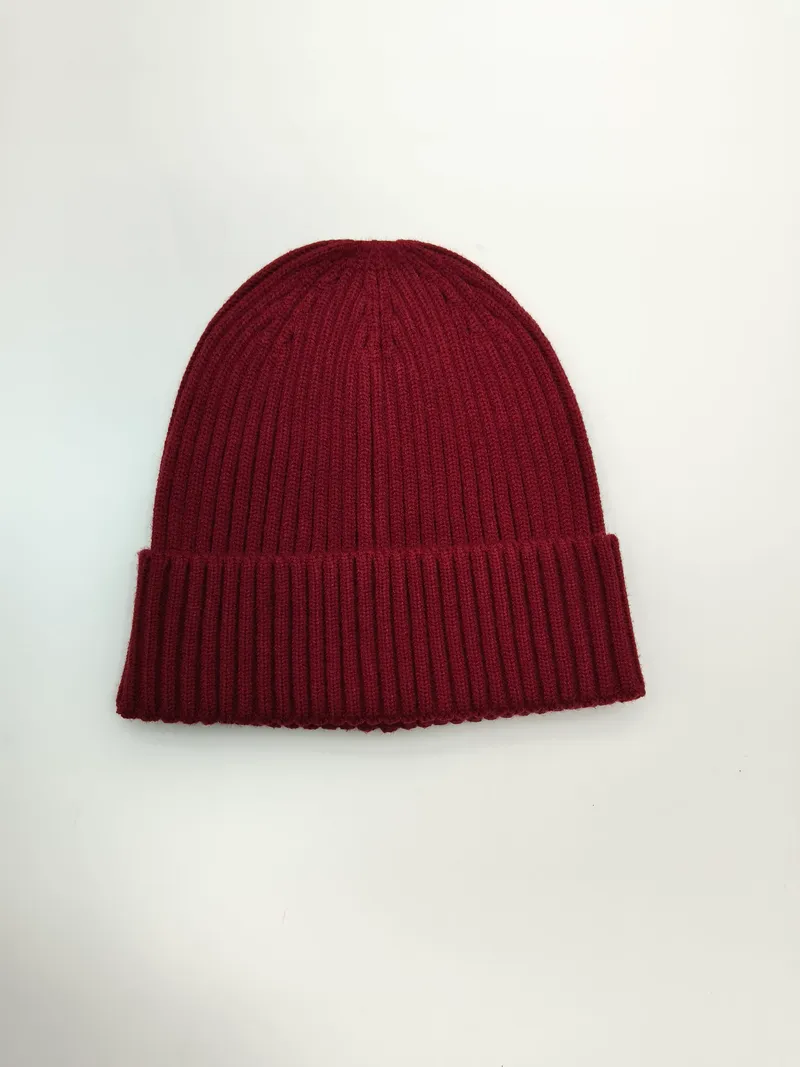 Weinrote Rippstrick-Beanie mit doppelt umgeschlagenem Bündchen, flach auf weißem Hintergrund liegend