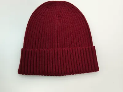 Weinrote Rippstrick-Beanie mit doppelt umgeschlagenem Bündchen, flach auf weißem Hintergrund liegend