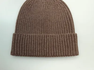 Taupefarbene fein gerippte Strickmütze mit Umschlagrand, auf weißem Hintergrund, weicher Wollmix-Winterbeanie