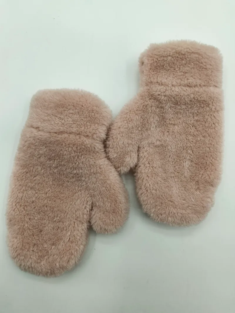 Ein Paar rosa flauschige Kunstfell-Winterfäustlinge, flach auf weißem Hintergrund liegend